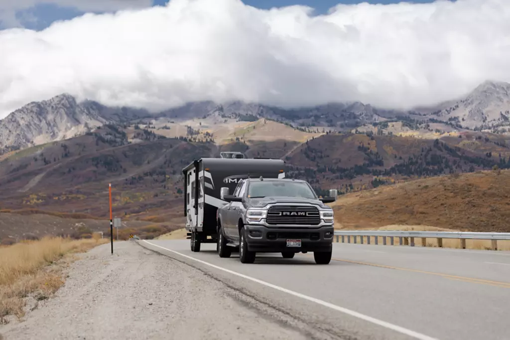 Truck towing Imagine XLS with mountains in the background