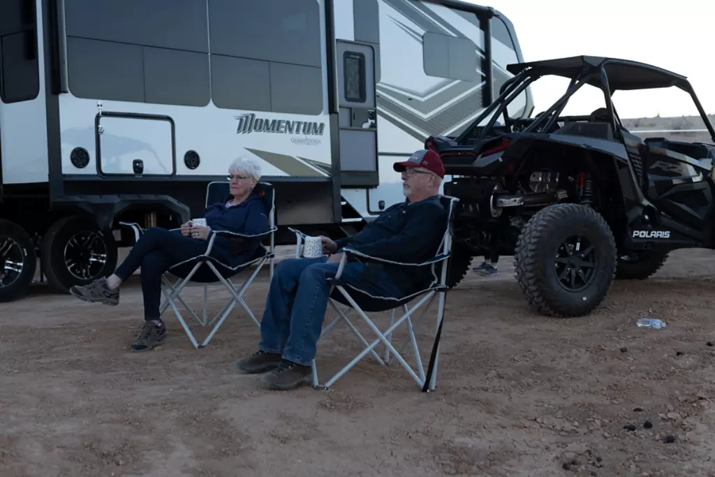 Couple sitting in front of Momentum with their ATV.