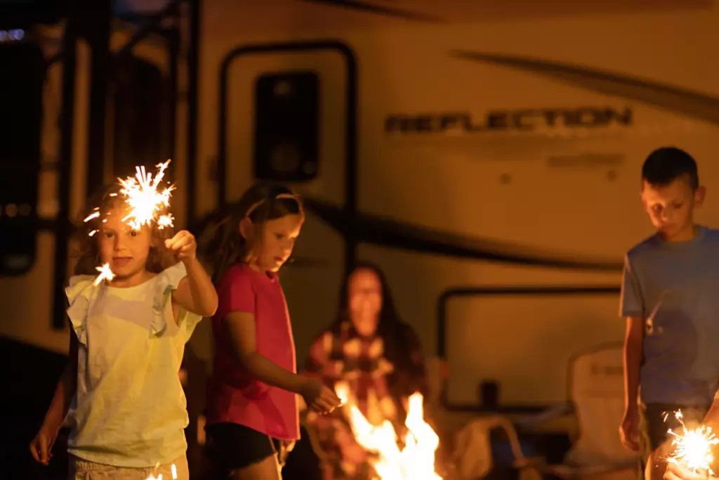 Man and woman grilling food in front of their Reflection. 