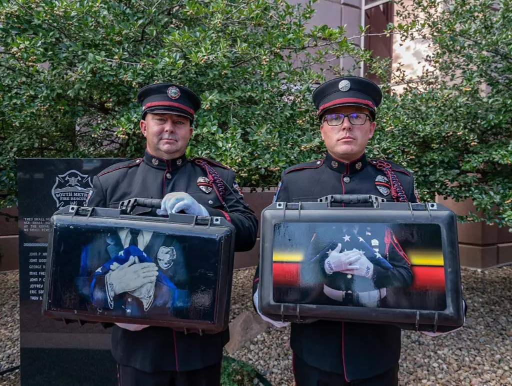 First responders holding flag cases.