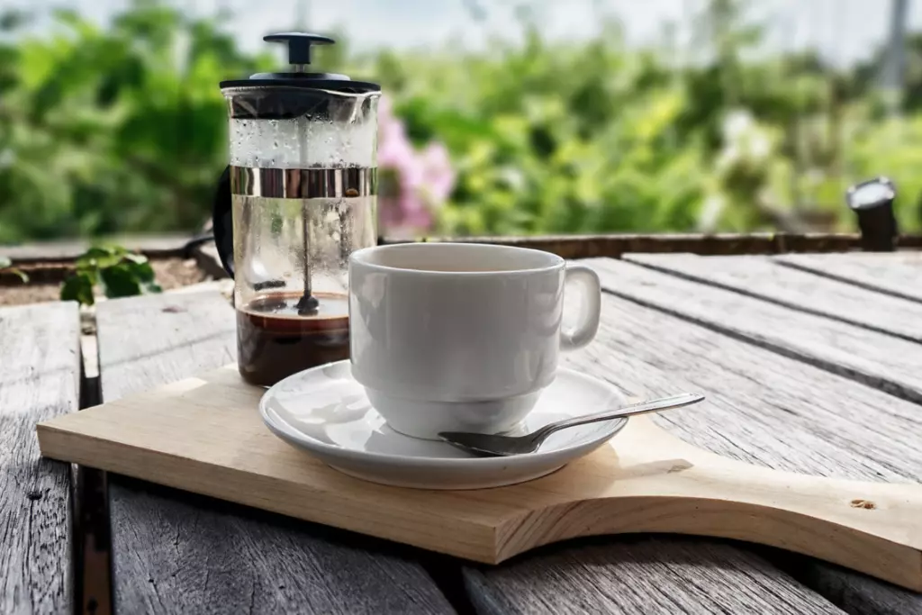 French press coffee maker and a cup of coffee.