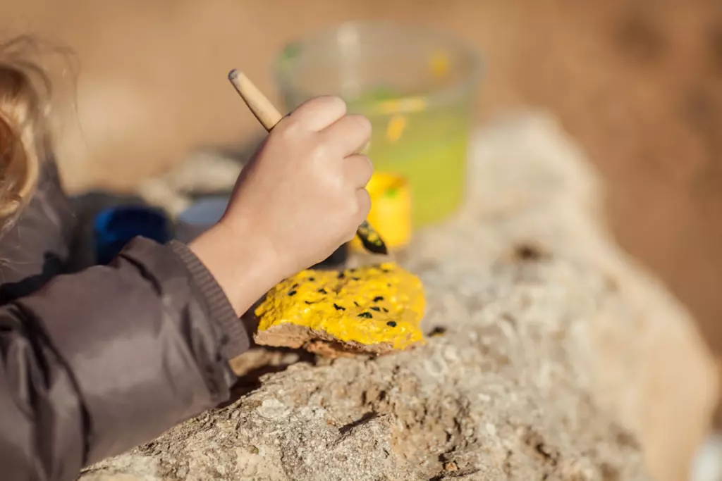 Childing painting rocks yellow