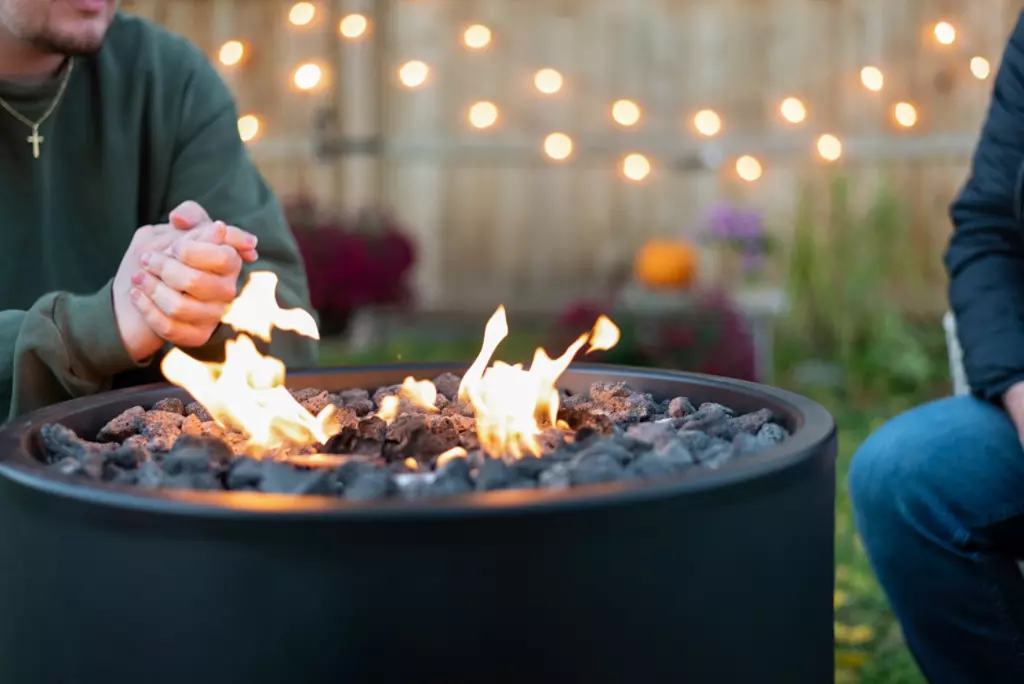 People getting warm by a portable fire.