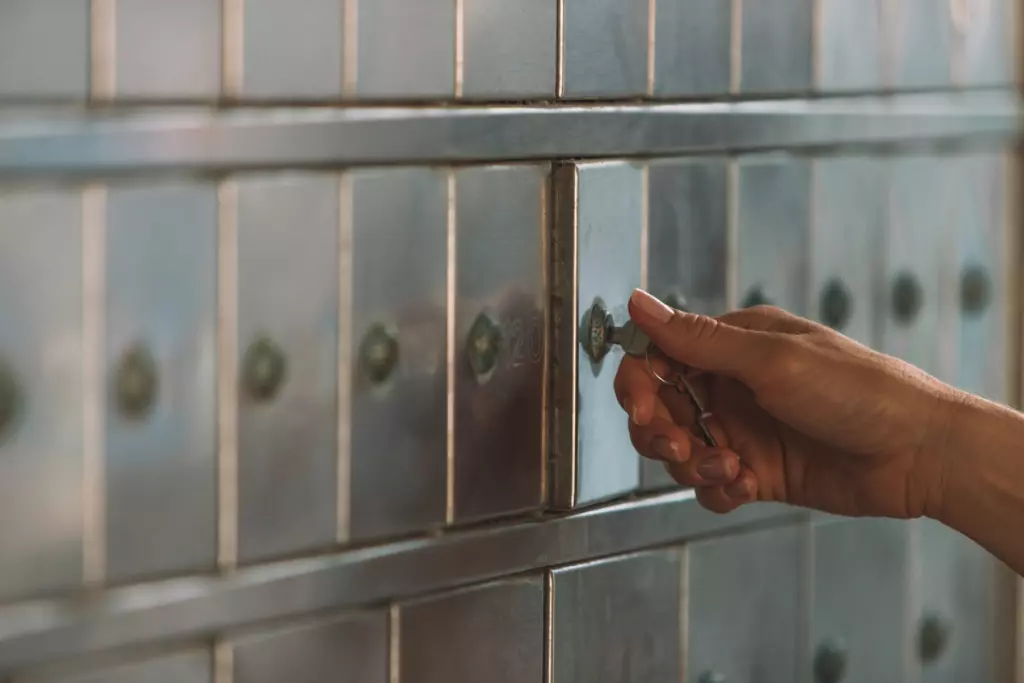 Woman's hand turning key on PO Box.