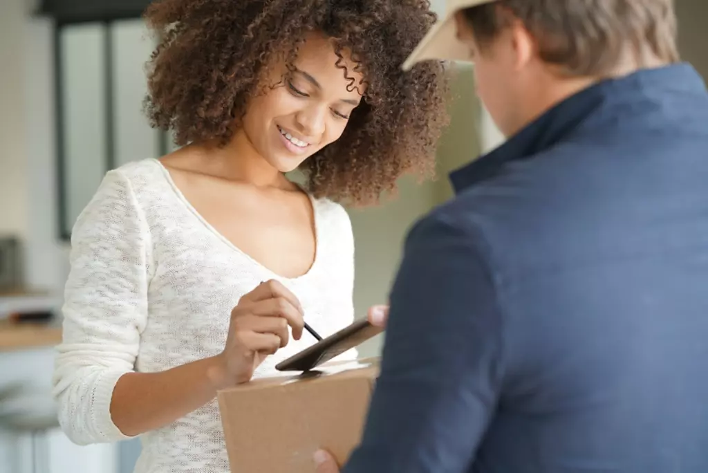 Woman signing for a package. 