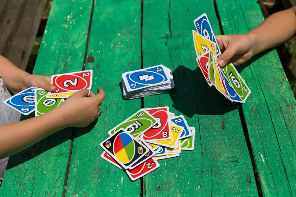children playing Uno at picnic table